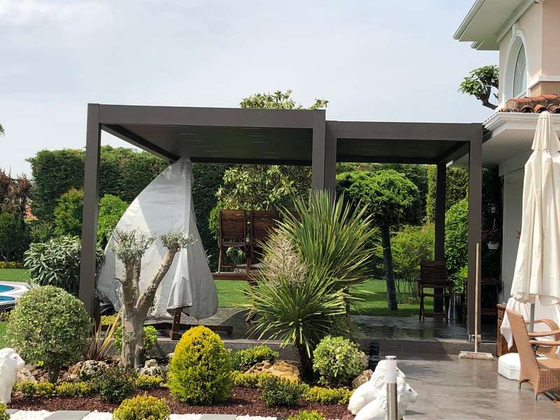 Havuzlu villa bahçesinde iki bölümlü antrasit bioklimatik pergola; kapalı şemsiyeler ve bakımlı peyzaj