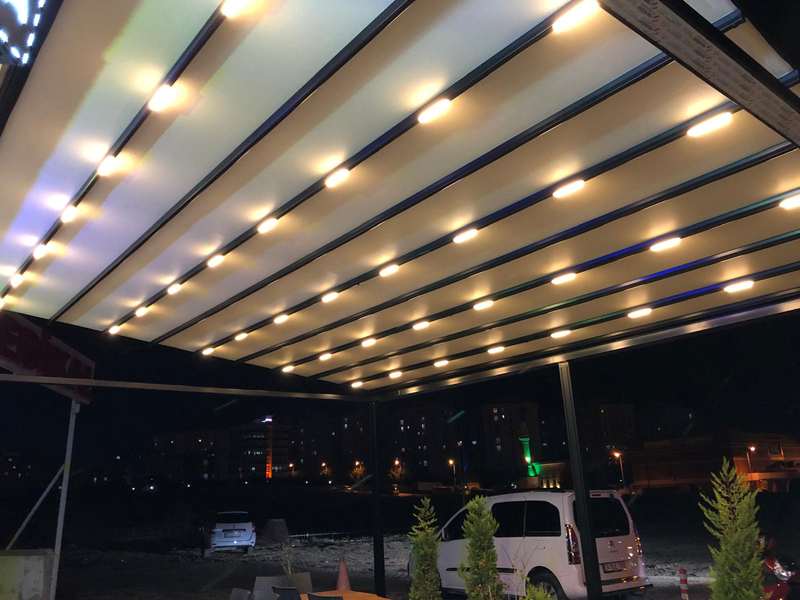 Gece çekilmiş katlanır çatı içeriden görünüm: LED spotlar ve şerit aydınlatma, arkada şehir ışıkları