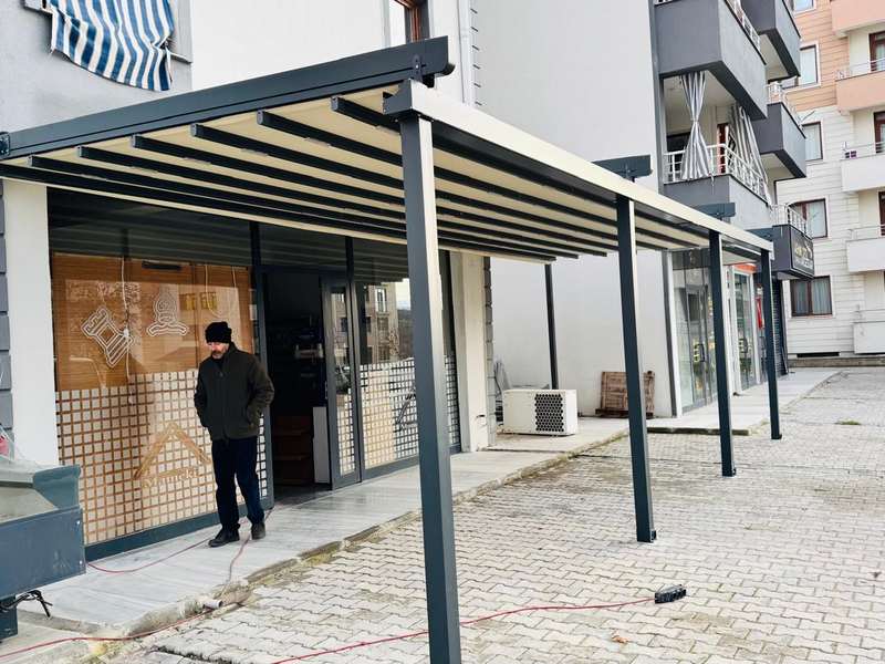 Tunceli Yaşam Manav ve Şarküteri cephesine kurulan antrasit renkli alüminyum pergola; dükkân girişini ve ürün sergileme alanını örtüyor